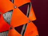 a large orange sculpture made of paper and metal