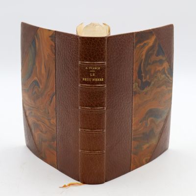 an old book with a leather cover and a gold coin in the middle