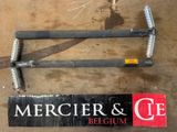 une paire de pinces posées par terre à côté d'un panneau