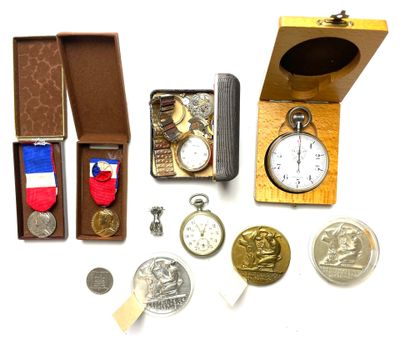 une boîte contenant une montre, une médaille, une autre médaille et d'autres objets