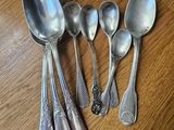 five spoons and two spoons sitting on a table