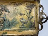 a metal tray with a bird and a bird on it