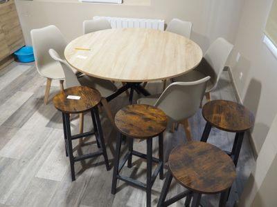 Dans une pièce, plusieurs chaises et une table sont empilées les unes sur les autres.