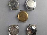 four different types of watches on a gray surface