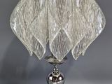 une lampe de table en verre avec un pied en métal et un abat-jour en verre