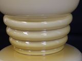 a white vase sitting on top of a table