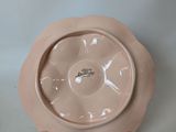 a pink plate with a clock on it sitting on a table