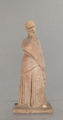une vieille statue représentant une femme avec un châle sur la tête