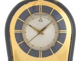 une image représentant une horloge dorée et noire sur fond blanc