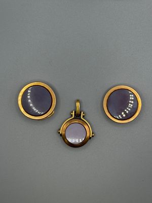 three pieces of jewelry are displayed on a gray surface