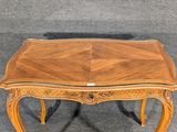a small wooden table with a glass top on a carpeted floor