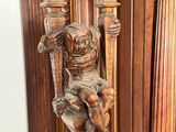 a statue of a man sitting on top of a wooden pole