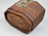 a wicker box with a flower decoration on it