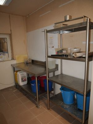 une étagère métallique dans une cuisine, avec deux seaux bleus