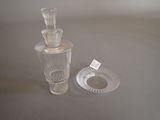 a glass bottle and a glass ashtray sitting on a table