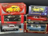 four model cars are in boxes on a black surface