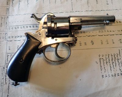 un revolver posé sur une feuille de papier