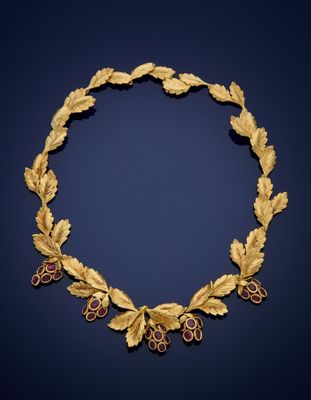 a gold and ruby necklace with leaves and berries