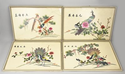 Quatre peintures chinoises représentant des oiseaux et des fleurs sont exposées sur une table