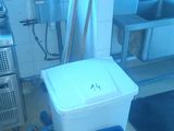 a blue bucket sitting in a kitchen next to a sink