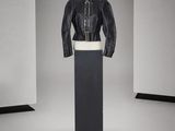 une photo d'un mannequin portant une veste et une jupe en cuir noir