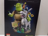 une boîte de figurines Lego représentant Shrek et l'âne, posée sur une table