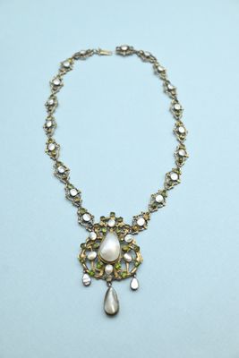 a close up of a necklace on a blue surface
