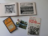Plusieurs vieux livres sont posés sur une table où se trouve une horloge