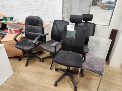 Plusieurs chaises de bureau sont alignées en rang dans une pièce.