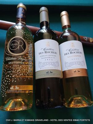 trois bouteilles de vin posées sur une table à côté d'une batte de baseball