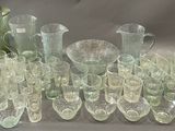 a lot of glasses and pitchers sitting on a table