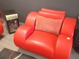 a red leather chair and a black and white rug in a room