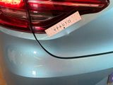 a close up of a blue car with a sticker on it ' s tail light