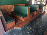 une rangée de bancs verts dans un coin d'un restaurant