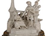 une statue représentant un homme et une femme assis sur un banc