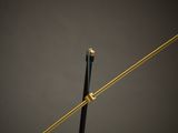 a close up of a black and gold clock on a black table