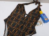 bathing suit and sunscreen lotion sitting on a white surface