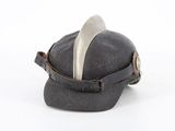 a black hat with a spoon in it on a white surface