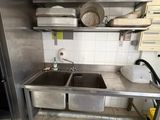 a kitchen with a stove, sink, and a refrigerator