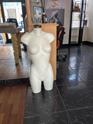 un mannequin blanc au milieu d'un sol carrelé noir