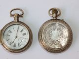 deux vieilles montres de poche posées l'une à côté de l'autre sur une table