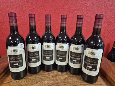 six bouteilles de vin sont alignées sur une table en bois