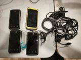 several cell phones are lined up on a table next to a computer mouse