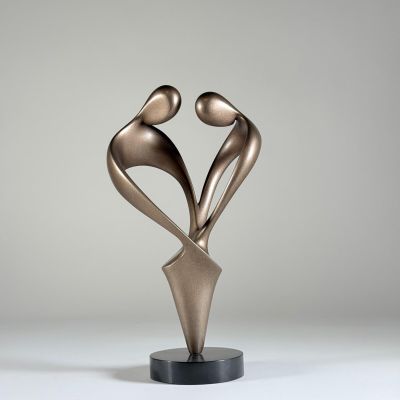 une sculpture en bronze représentant deux personnes se tenant la main, posée sur un socle noir