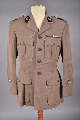 un uniforme militaire sur un mannequin, devant un fond gris