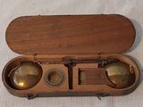 un coffret en bois contenant deux clochettes en laiton