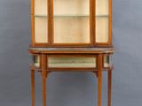 a wooden display cabinet with glass shelves and shelves on top