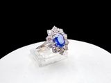 an image of a diamond and sapphire ring sitting on top of a white surface