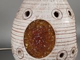 a white vase with a brown and yellow decoration on it