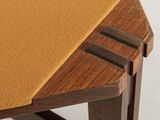 close up view of the top of a wooden table with a brown cloth on it